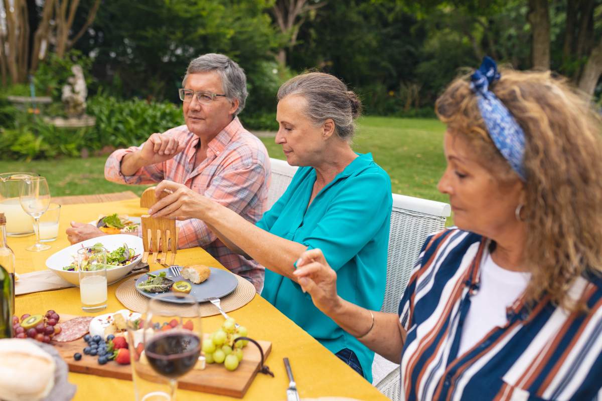 A group of senior friends enjoying a meal outdoors