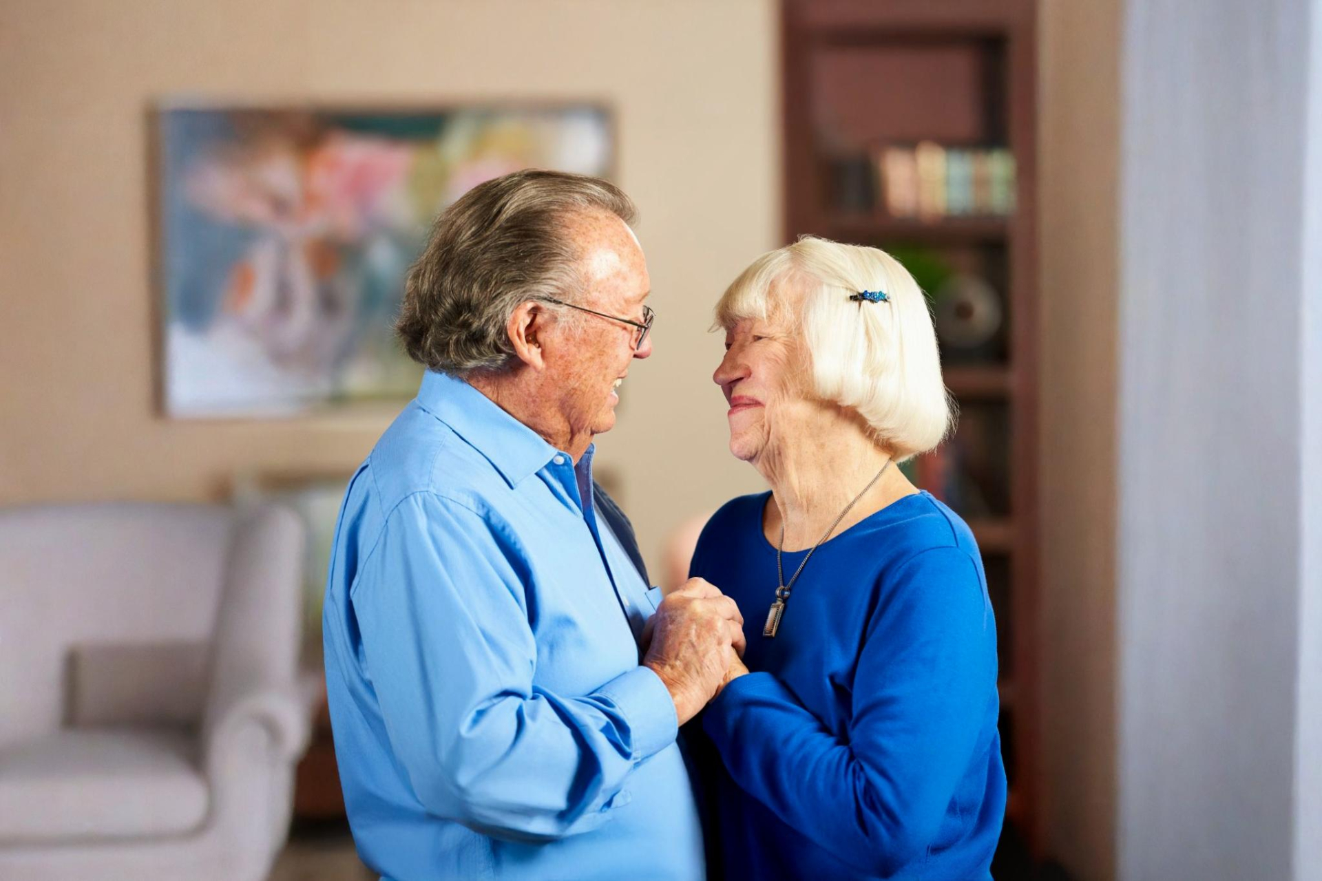A senior couple dancing together, smiling at each other.